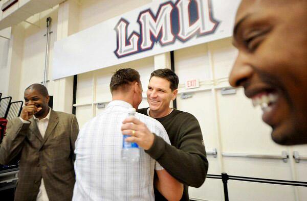 As former Loyola Marymount players gather for the 20th anniversary of the team's run to the NCAA tournament's Elite Eight, Jeff Fryer and Brian McCloskey greet one another in the university's gym.