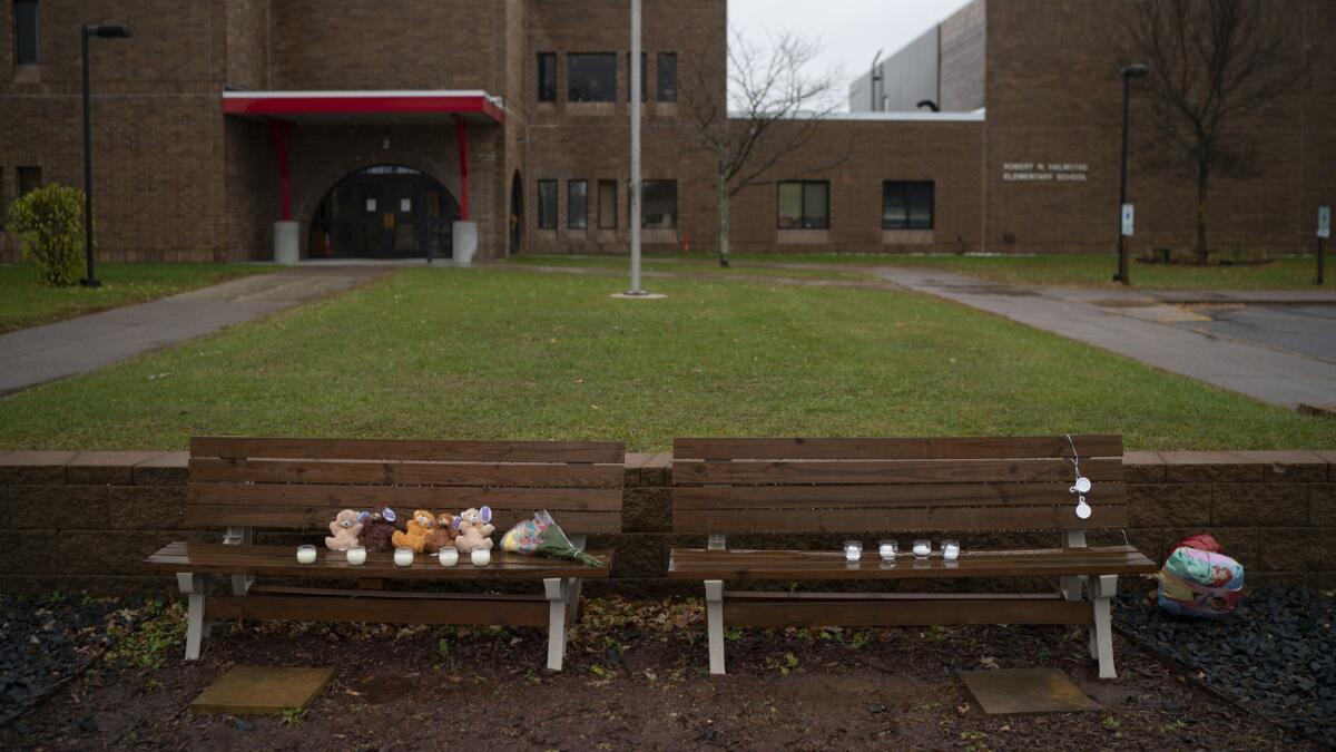 Teddy bears, flowers, and candles were placed on benches outside Halmstad Elementary School in Chippewa Falls, Wis. as a memorial to the three Girl Scouts who were struck and killed by a driver who fled the scene but later turned himself in.