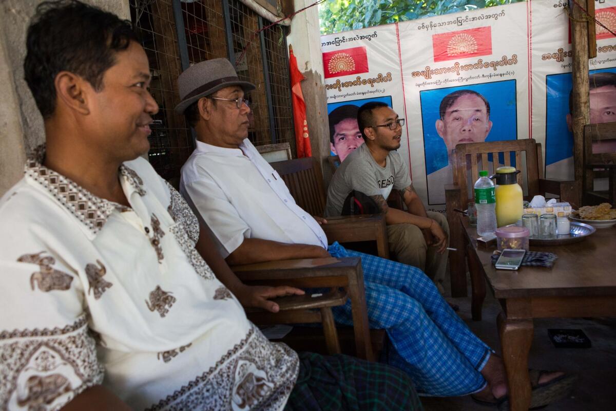 National Unity party candidate Thu Ryain Shwe, right, at 26 one of the youngest candidates running for parliament, visits with two of his National Development party rivals in Zigon, Myanmar, on Nov. 7, 2015, the day before the election, when no campaigning is allowed.