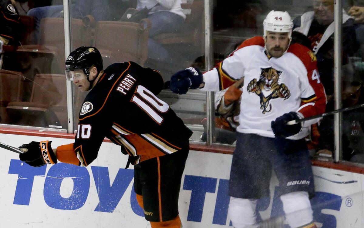 Corey Perry, left, back from a five-game absence because of the mumps, checks Florida defenseman Erik Gudbranson on Sunday.