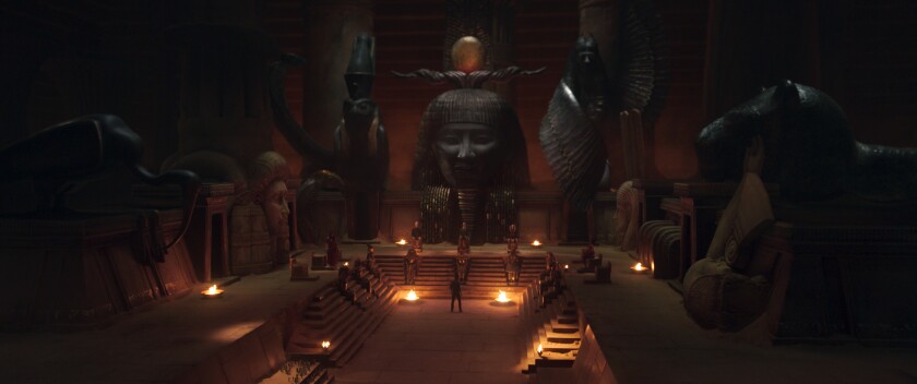 a man standing below a seated council inside a tomb