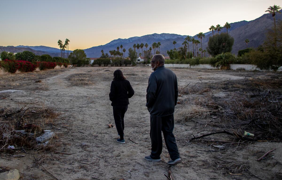 Joe Abner and his wife, Vera, walk through a vacant lot that was once part of Section 14 in Palm Springs. 