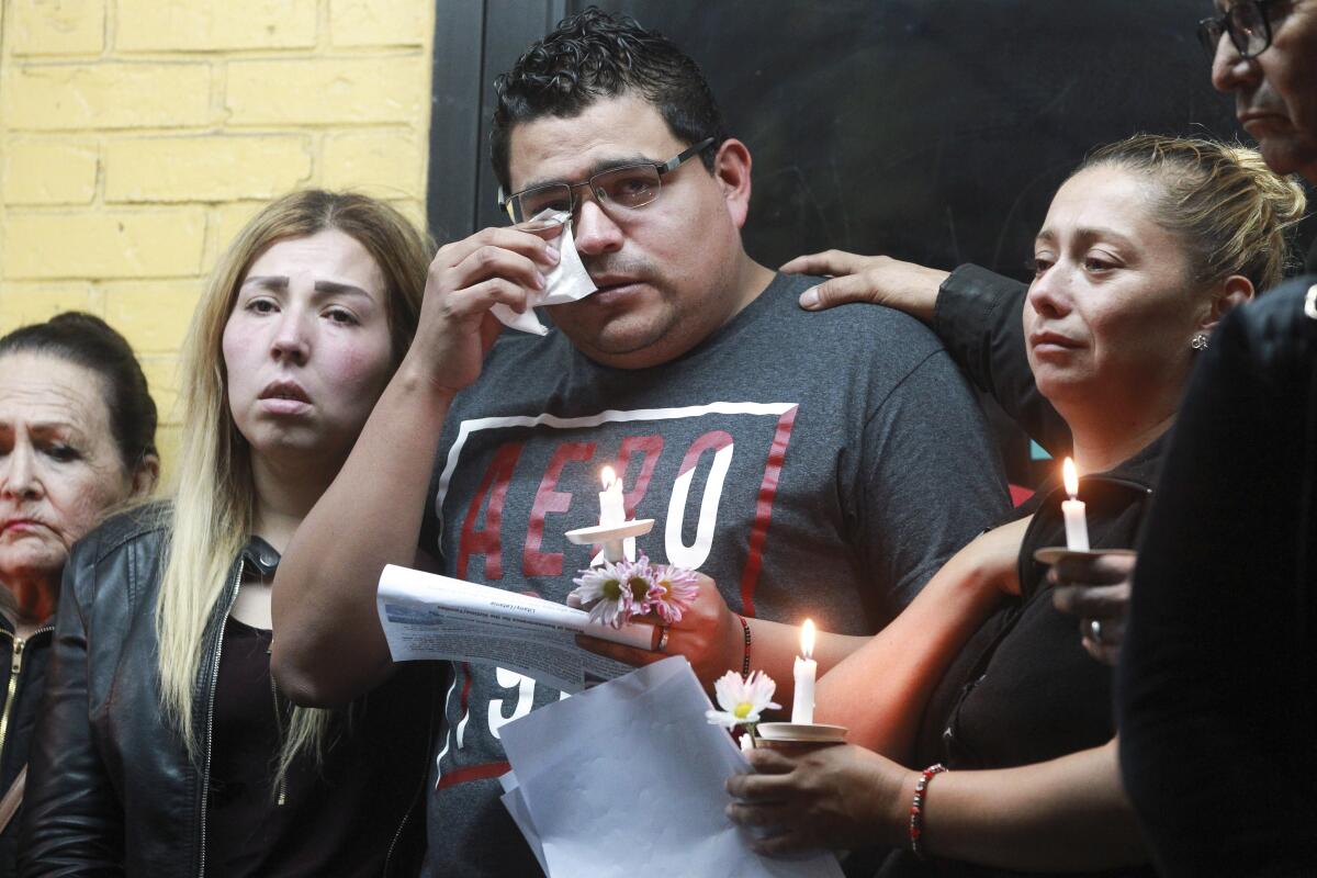 Ramon Mendoza, husband of Maribel Iba``nez, who was shot and killed Wednesday night while working at a Church's Chicken restaurant, wipes tears during a candlelight vigil for his wife Friday.