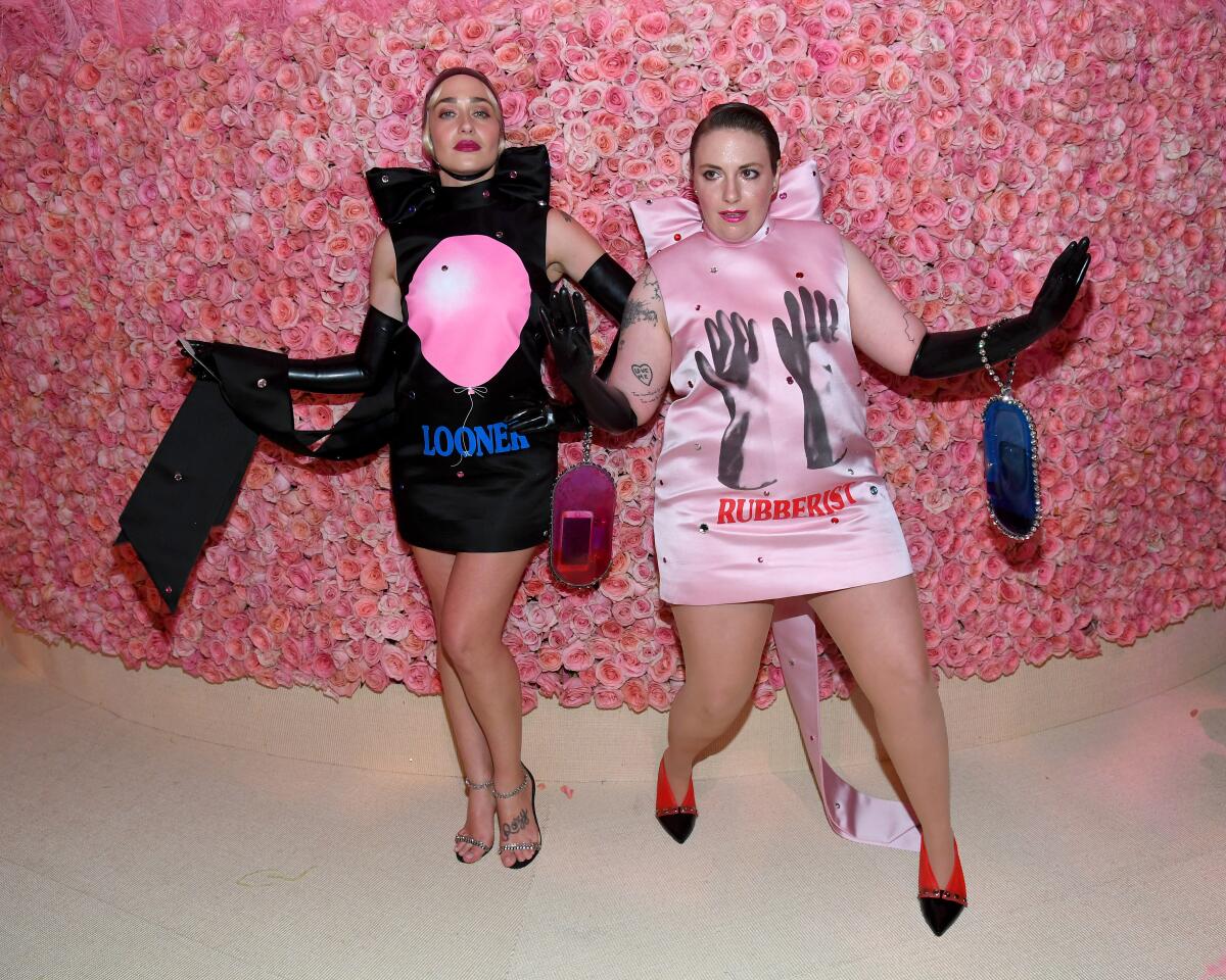 Jemima Kirke wears a black fetish-inspired dress and Lena Dunham wears a pink one
