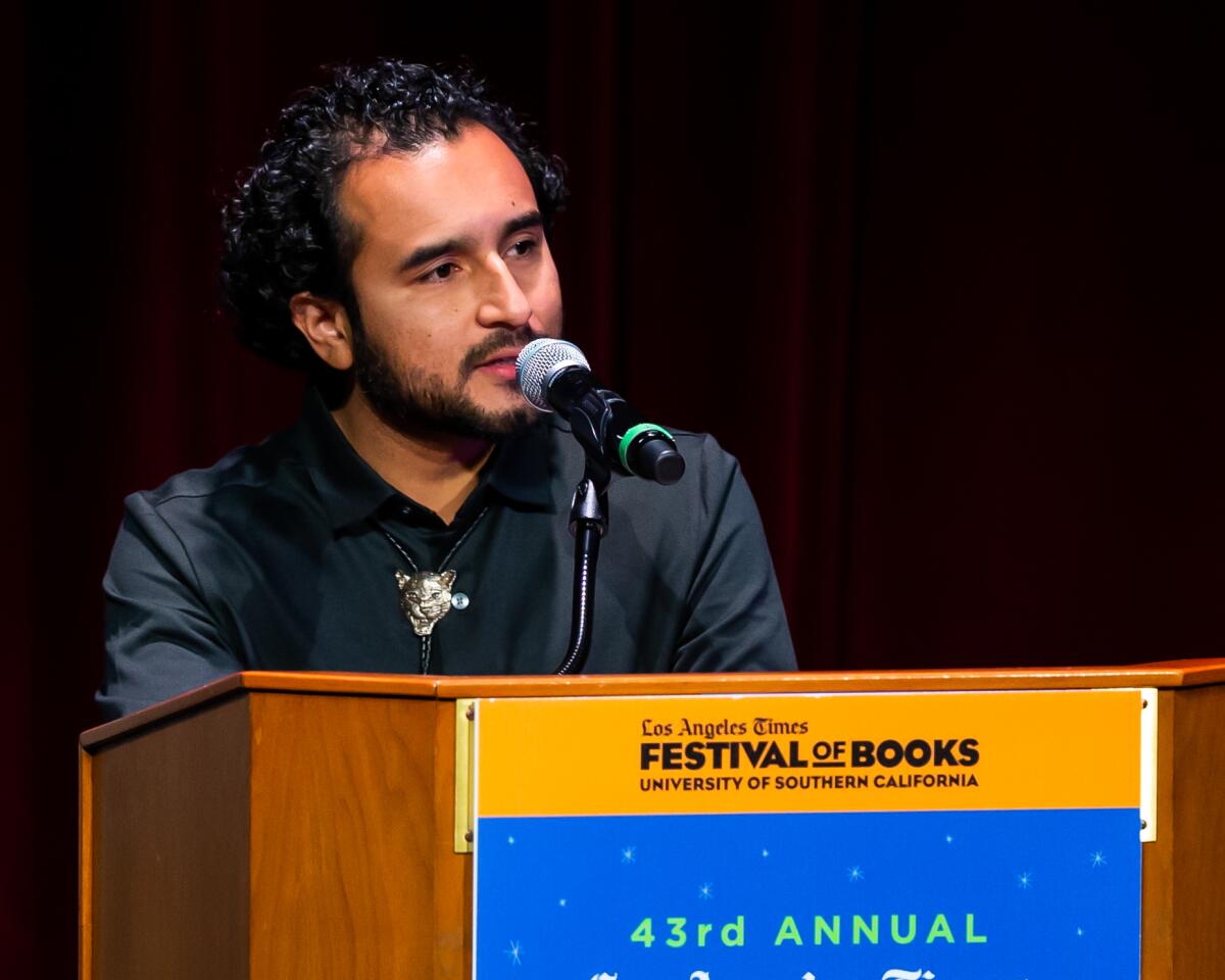 Javier Zamora, author of "Solito," accepts the Christopher Isherwood Prize at the Los Angeles Times Book Prizes.