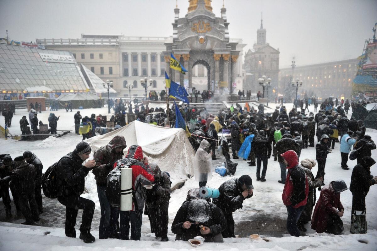 Pro-European demonstrators have dinner during a protest in Kiev. Ukrainian police forced protesters who have blockaded the government headquarters in central Kiev for a week to move away from the building.