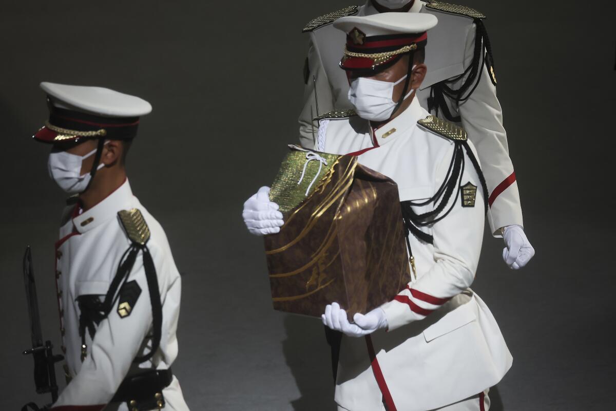 Servicemen holding urn with former Japanese Prime Minister Shinzo Abe's ashes