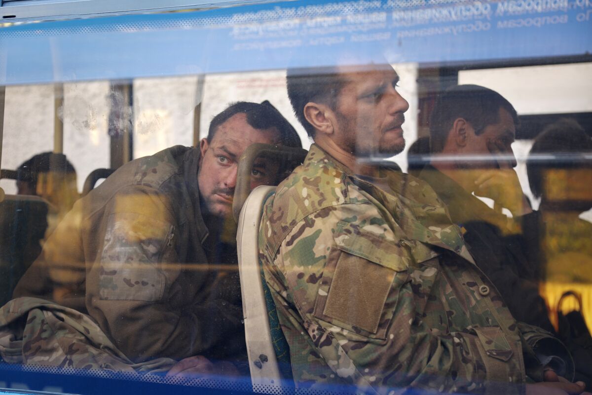 FILE - Ukrainian servicemen sit in a bus after they were evacuated from the besieged Mariupol's Azovstal steel plant, near a remand prison in Olyonivka, in territory under the government of the Donetsk People's Republic, eastern Ukraine, Tuesday, May 17, 2022. Breaking its silence on prisoners of war, the Red Cross said Thursday, May 19, 2022 it has registered “hundreds” of Ukrainian prisoners of war who left the giant Azovstal steel plant in Mariupol after holding out in a weeks-long standoff with besieging Russian forces. (AP Photo/Alexei Alexandrov, File)