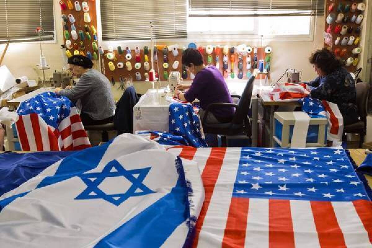 Workers in the town of Kfar Saba ready U.S. and Israeli flags in preparation for President Obama's visit to Israel and the West Bank.