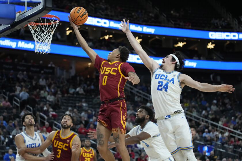 Southern California's Boogie Ellis (0) shoots around UCLA's Jaime Jaquez Jr. (24) during the second half of an NCAA college basketball game in the semifinal round of the Pac-12 tournament Friday, March 11, 2022, in Las Vegas. (AP Photo/John Locher)