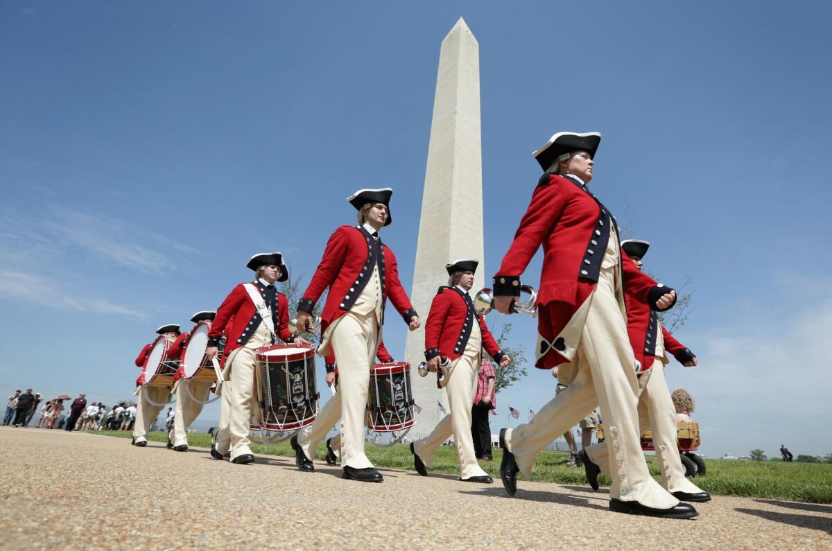Members of the U.S. Army Old Guard Fife and Drum Corps march in front of the Washington Monument during a reopening ceremony Monday.