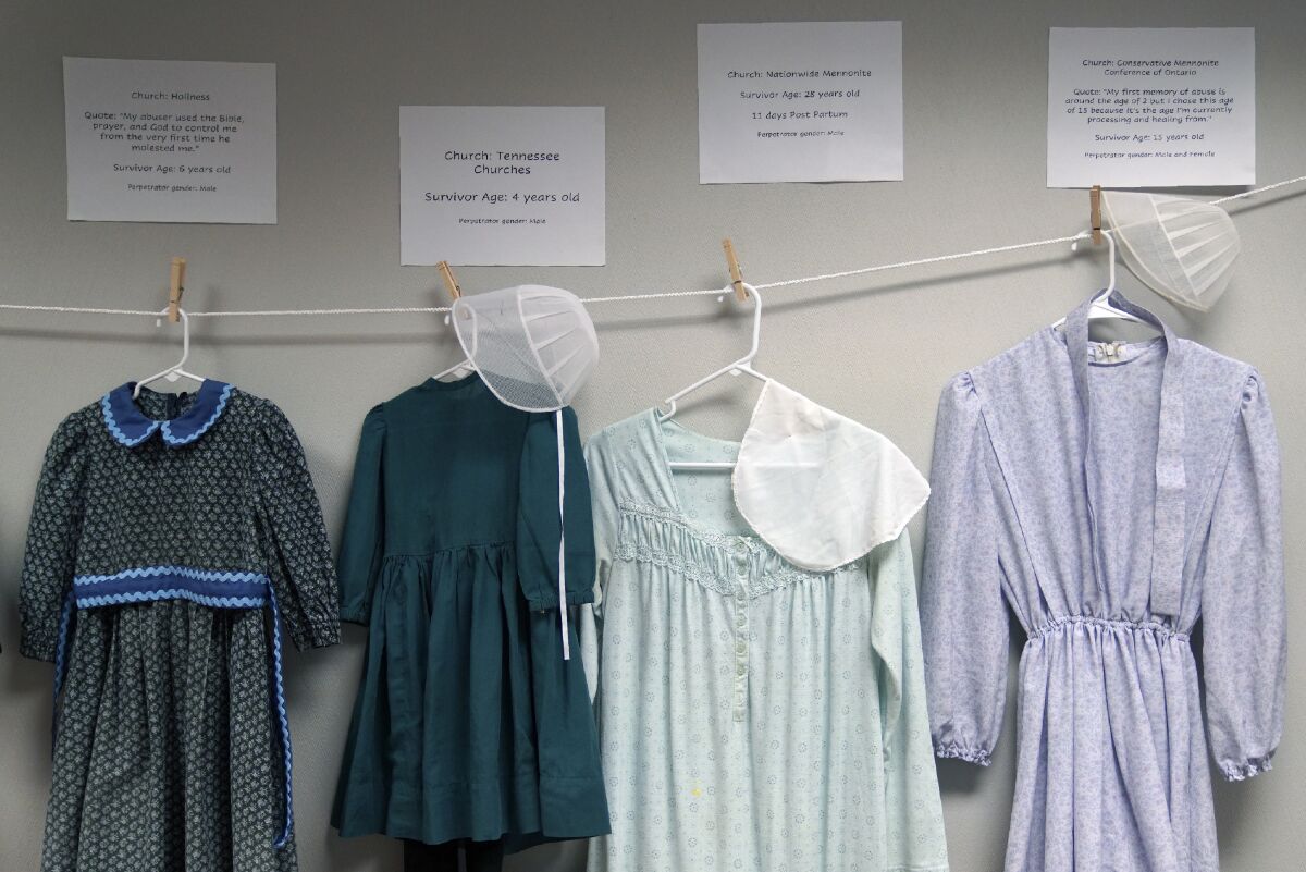FILE - Dresses donated by sexual assault survivors from Amish and other plain-dressing religious groups hang on a clothesline beneath a description of each survivors' age and church affiliation, on Friday, April 29, 2022, in Leola, Pa. The exhibit's purpose was to show that sexual assault is a reality among children and adults in such groups. Similar exhibits held nationwide aim to shatter the myth that abuse is caused by a victim's clothing choice. (AP Photo/Jessie Wardarski, File)