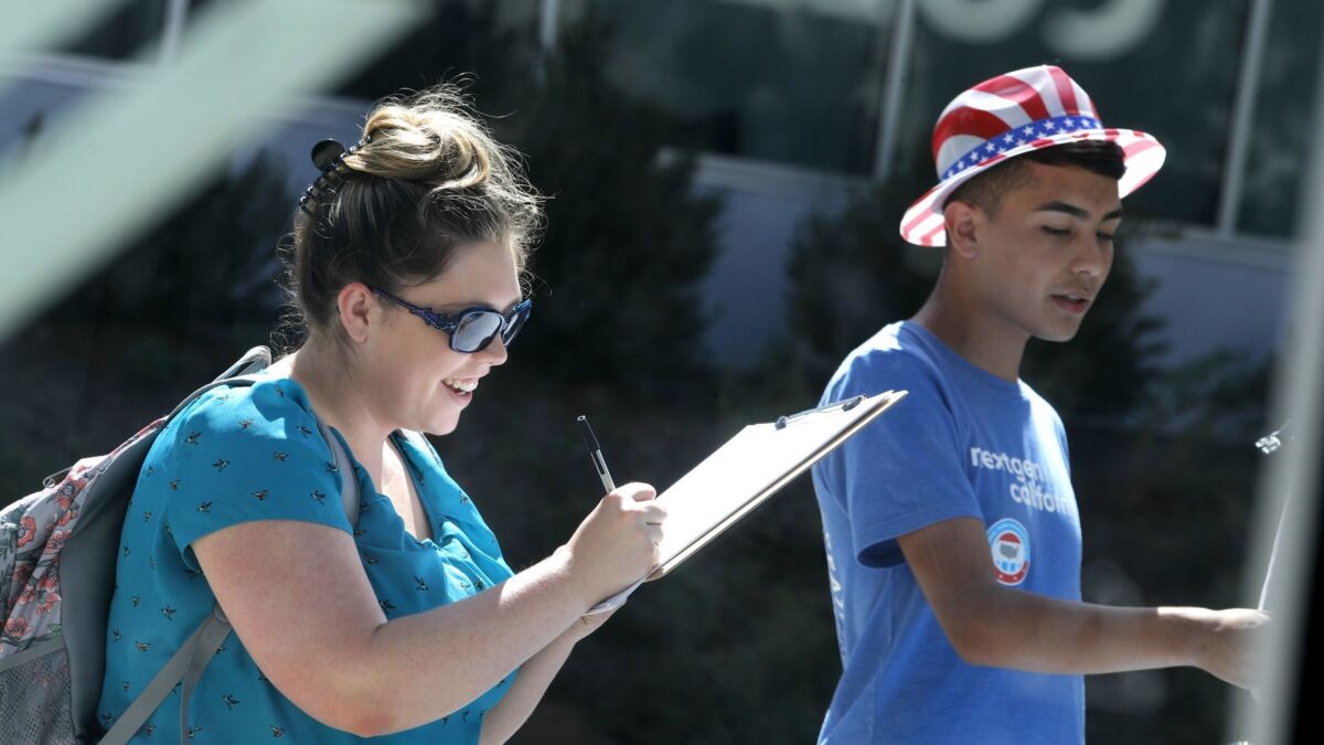 Daniel Nieto, 18, right, helps Samantha Skidmore, 24, register to vote on the College of the Canyons campus.