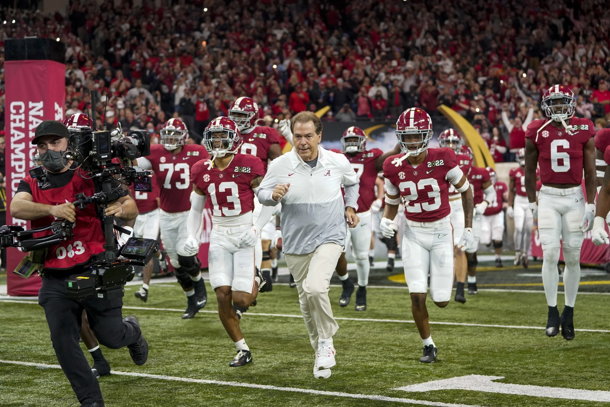 Alabama coach Nick Saban leads his team on the field.