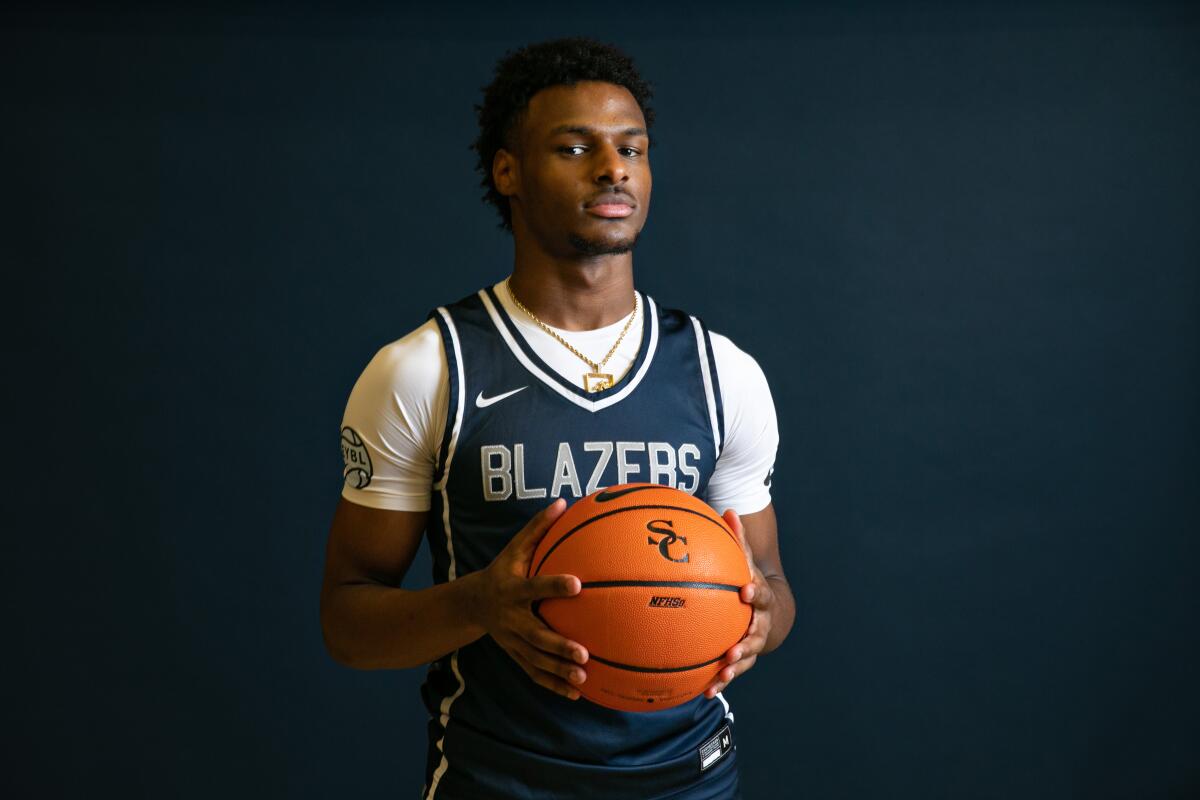 Bronny James holds a basketball in a Sierra Canyon uniform.