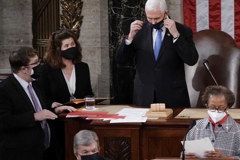 In this Jan. 6, 2021, photo, Senate Parliamentarian Elizabeth MacDonough, left, works beside Vice President Mike Pence during the certification of Electoral College ballots in the presidential election, in the House chamber at the Capitol in Washington. Shortly afterward, the Capitol was stormed by rioters determined to disrupt the certification. MacDonough has guided the Senate through two impeachment trials, vexed Democrats and Republicans alike with parliamentary opinions and helped rescue Electoral College certificates from a pro-Trump mob ransacking the Capitol. (AP Photo/J. Scott Applewhite)