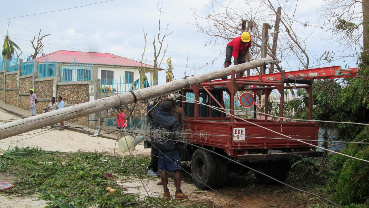 This handout photo obtained from the Agency for Technical Cooperation and Development Assistance on October 7, 2016 shows men making repairs to electrical lines in the devasted town of Jeremie, west Haiti, following Hurricane Matthew.