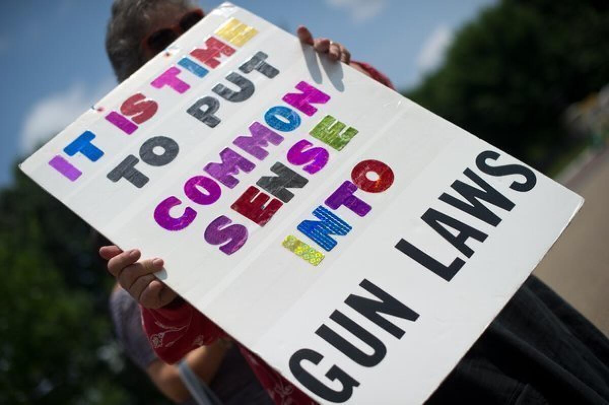 People calling for stricter gun laws hold signs during their weekly protest outside the White House. The Obama administration says it is doing what it can to improve gun safety but that measures won't be effective without action by Congress.
