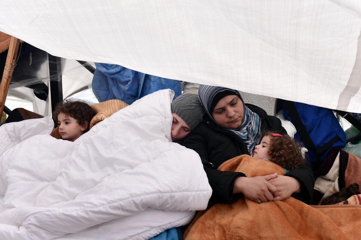 Syrian refugees rest in a makeshift shelter in Athens on Dec. 8. About 300 have been camped out for nearly three weeks on a square across from the Greek parliament as they seek assistance to move on to other European countries.