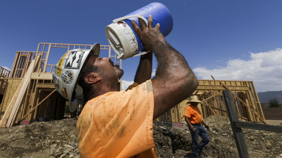 Reginaldo Ramirez gulps cold water after working in heat that reached 111 degrees in San Bernardino in August 2017. Heat waves will become more persistent, severe and health-threatening in California if greenhouse gas emissions continue to rise, the state's report warns.