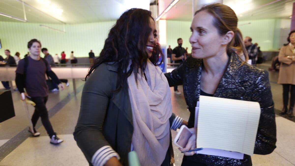Areej Ali, left, thanks attorney Courtney Black after she was detained upon her arrival from Sudan.