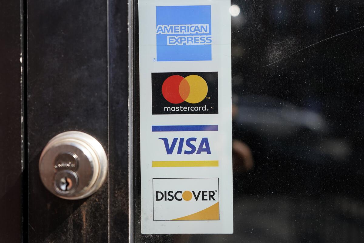 Credit card logos are displayed on a business's door