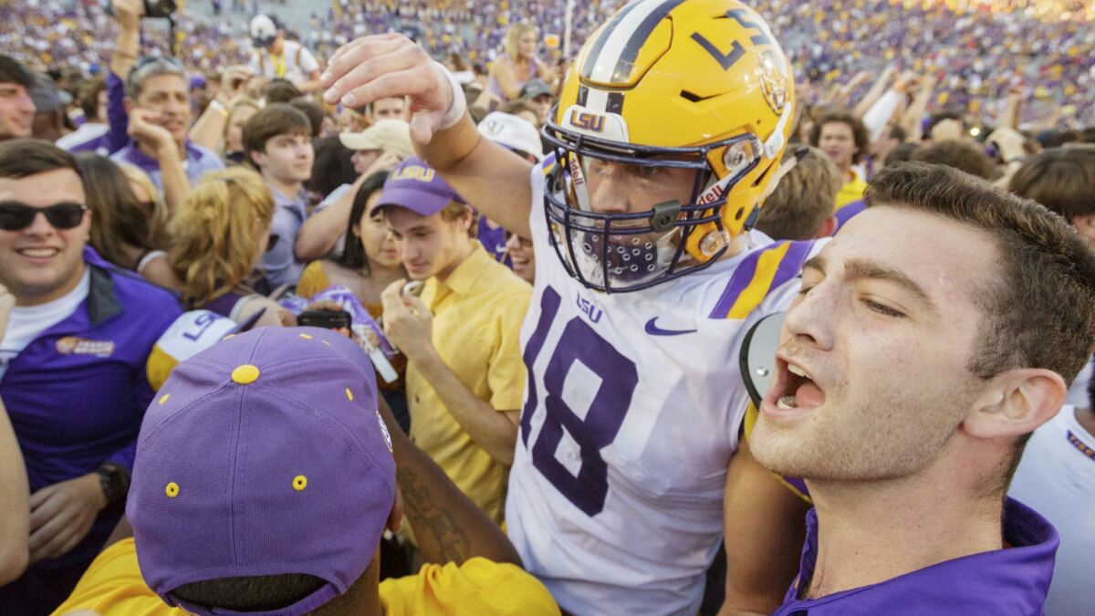 Louisiana State tight end Foster Moreau is surrounded as fans rush the field after the Tigers' 36-16 win over Georgia on Saturday in Baton Rouge, La.