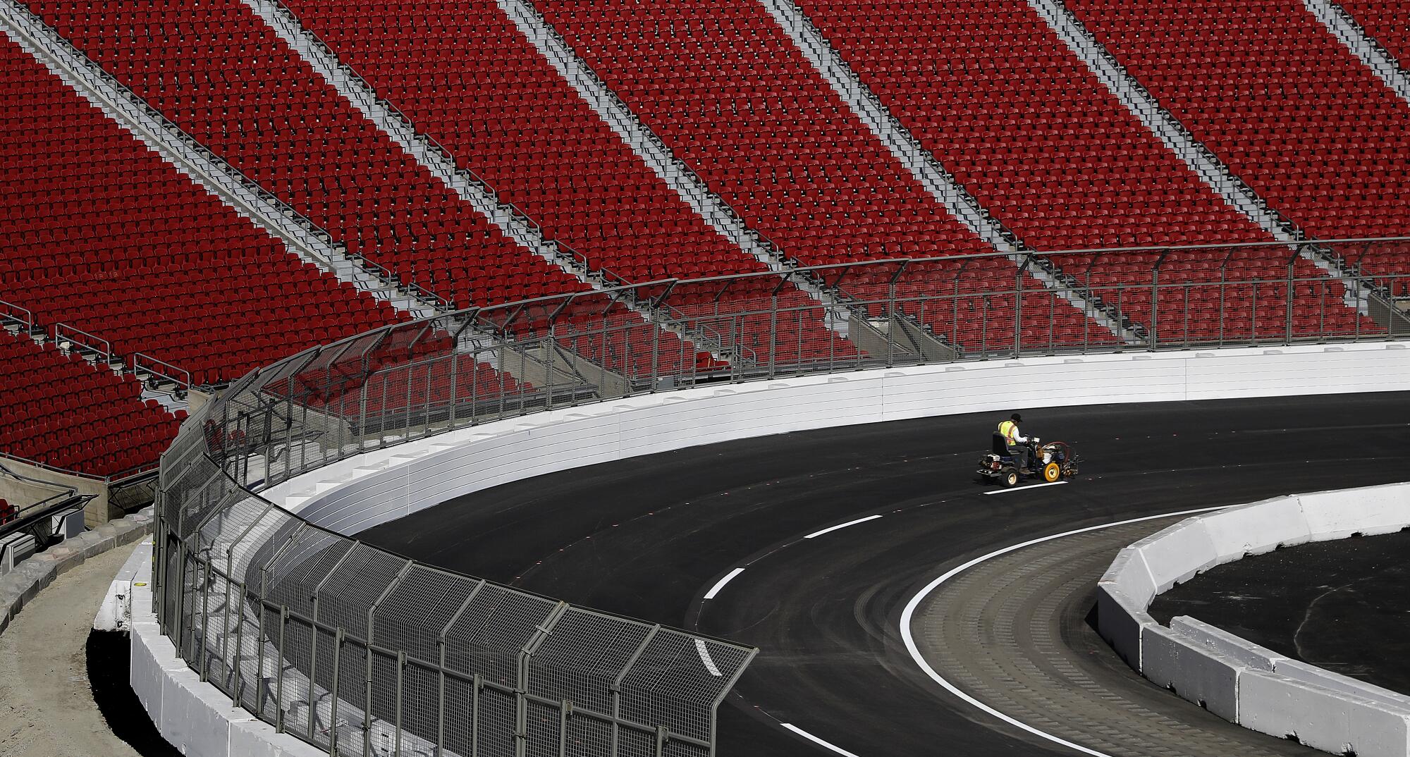 Lane lines are painted ahead of the NASCAR race at the L.A. Memorial Coliseum.