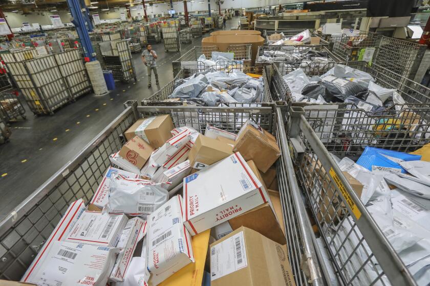 Postal workers sort parcels at Margaret L. Sellers Processing and Distribution Center at the USPS Carmel Mountain Post Office on May 14, 2020 in San Diego, California. The post office is seeing a huge increase in the amount of packages its handling.