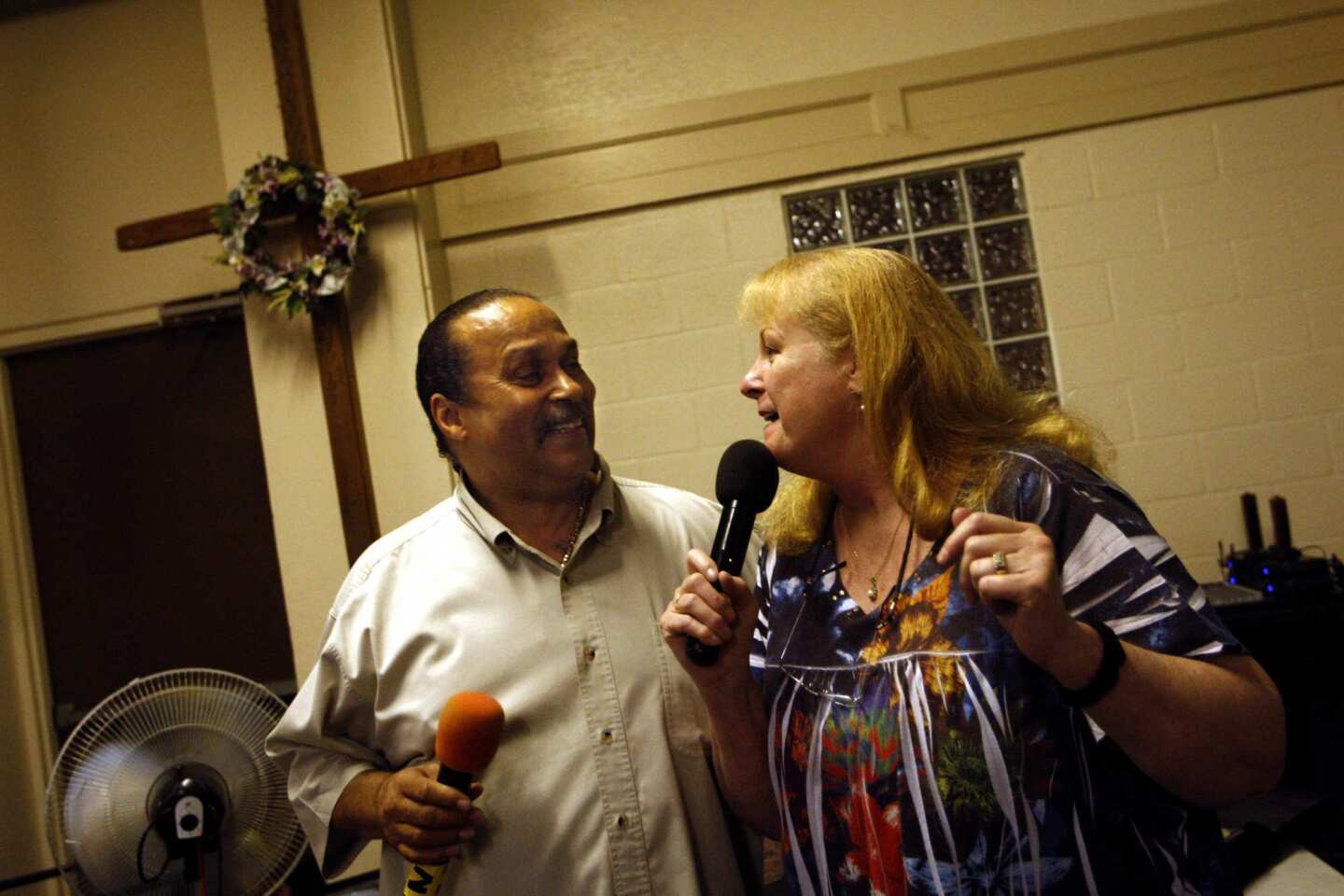 Pastor Tony Stallworth and his wife, Lucy, do a duet during karaoke night at the Central City Community Church of the Nazarene on skid row in Los Angeles on July 11, 2012. Lucy is the ongoing DJ who plays people's requests and Pastor Tony is the master of ceremonies. For the past 15 years the Stallworths have held a karaoke party every Wednesday night at their church for people living on the streets of skid row or those living in shelters and transitional housing.