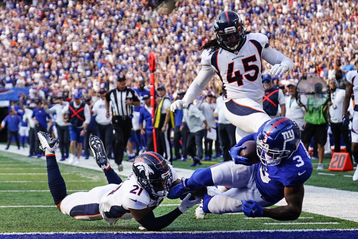 Denver Broncos' Ronald Darby (21) tackles New York Giants' Sterling Shepard (3) as Shepard scores a touchdown during the first half of an NFL football game Sunday, Sept. 12, 2021, in East Rutherford, N.J. (AP Photo/Matt Rourke)