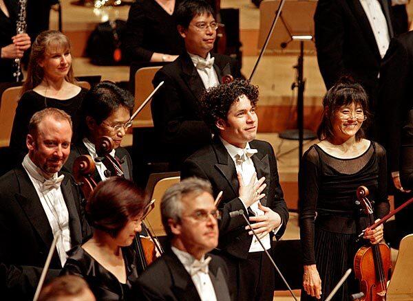 Gustavo Dudamel stands amid the L.A. Philharmonic as he receives applause from the cheering audience at the gala concert.