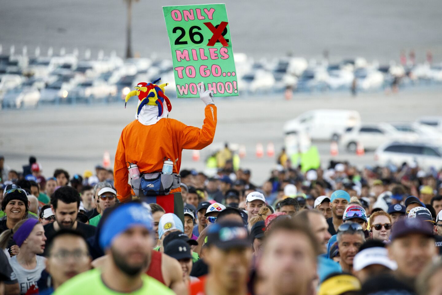 Ed Ettinghausen holds up a sign to cheer on fellow runners near the downtown start of the L.A. Marathon on Sunday.