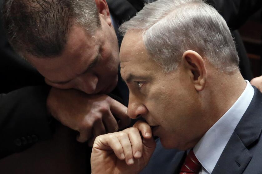 Israeli Prime Minister Benjamin Netanyahu, right, listens to an advisor during a vote Dec. 3 to dissolve the Knesset.