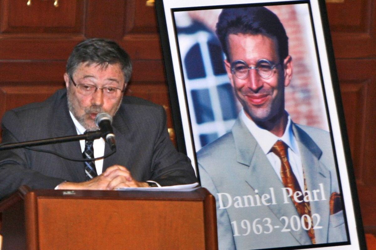 Dr. Judea Pearl, father of Daniel Pearl, speaks near a portrait of the slain American journalist in Miami Beach in 2007.