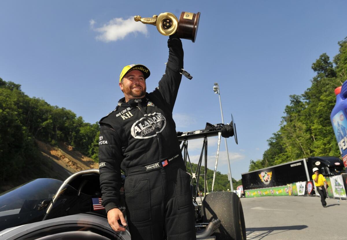 Top Fuel driver Shawn Langdon lifts his trophy after winning the NHRA Thunder Valley Nationals in Bristol, Tenn., last year.
