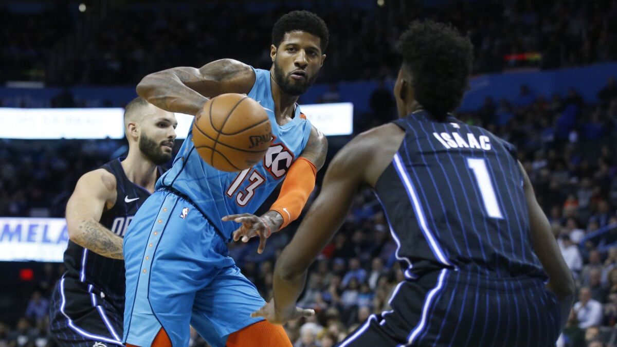 Oklahoma City Thunder forward Paul George, center, passes the ball during a game against the Orlando Magic on Feb. 5.