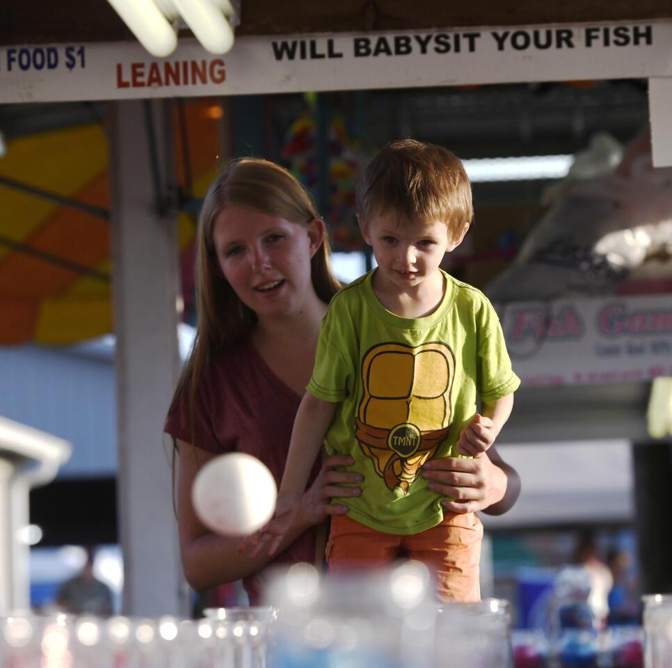 Sara Malinauskas and her son Colton Mayne, 3, of Woodbine, play the goldfish toss game at the Winfield fire company carnival Wednesday, July 10, 2019.
