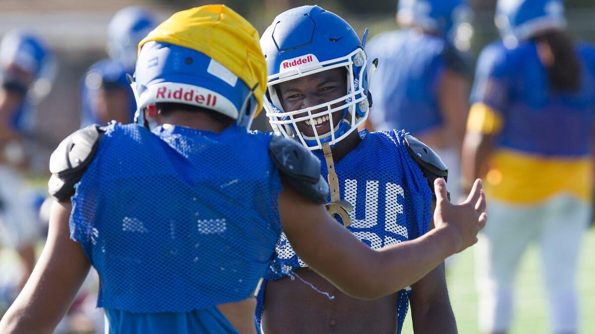 Two-way player Kishaun Sykes greets a teammate during recent Fountain Valley football practice.