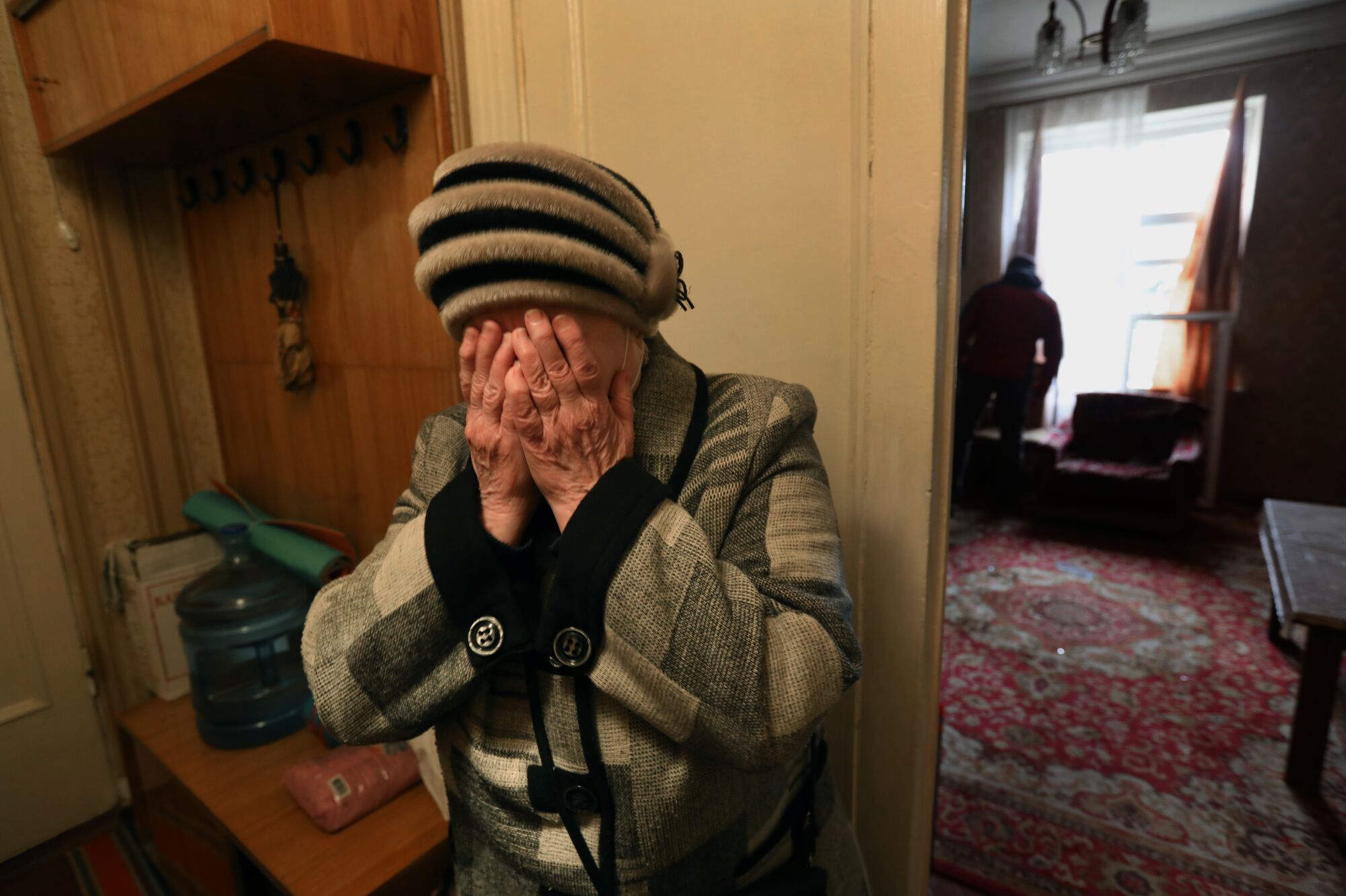 A elderly woman cries.