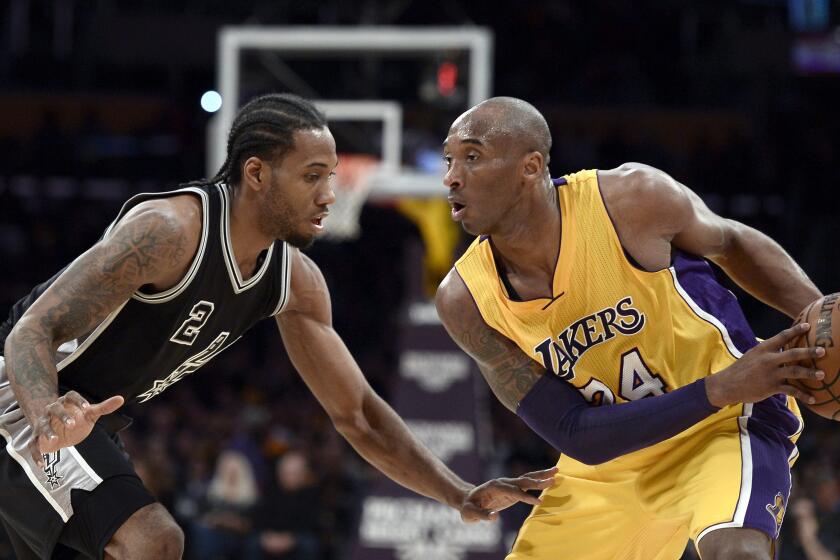 Lakers forward Kobe Bryant goes to work against Spurs forward Kawhi Leonard on Jan. 22, 2016.
