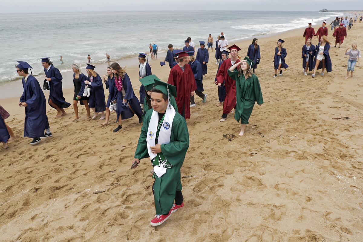A group of Costa Mesa and Estancia High School seniors participate in a walk from Newport Elementary School to Balboa Pier.