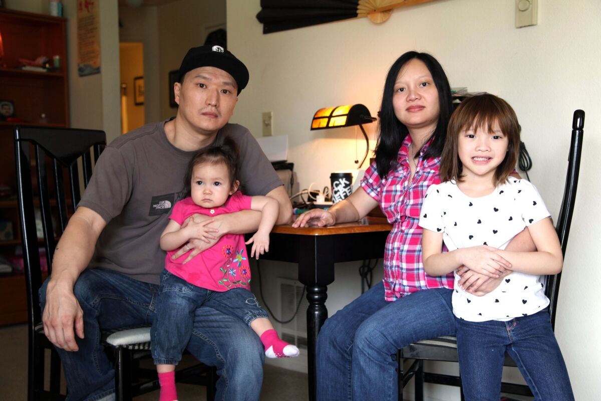Korean adoptee Adam Crapser with his wife, Anh Nguyen, and daughters, Christal, 1, and Christina, 5, in the family's living room in Vancouver, Wash., in 2015.