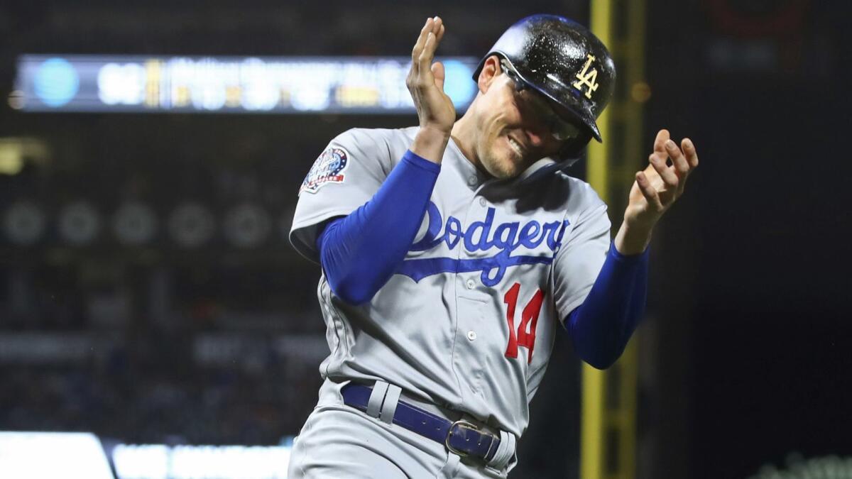 Dodgers' Enrique "Kike" Hernandez celebrates after scoring against the San Francisco Giants during the third inning on Friday in San Francisco.