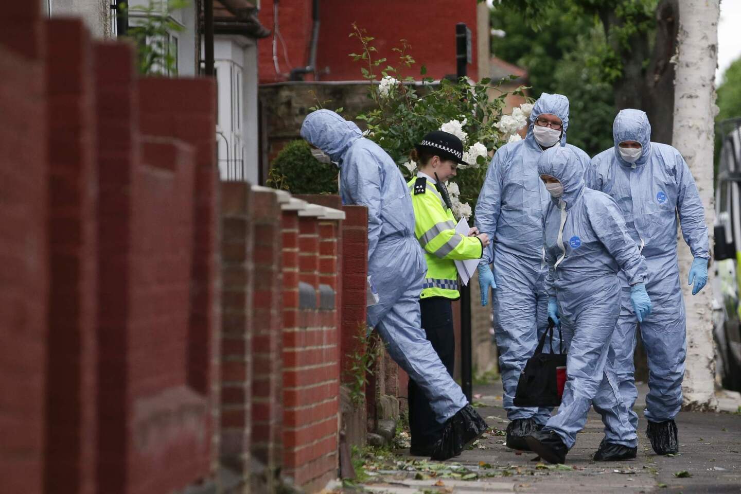 Police forensics officers work at a residential property in east London on Monday as part of their investigations into the terrorist attacks.