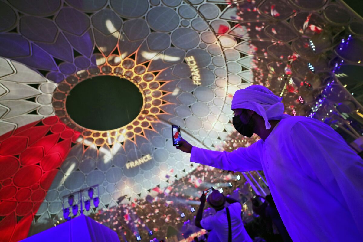 A man takes selfie under the dome of Al Wasl Plaza coloured in French national flag, during a French ceremonial day at the Dubai Expo 2020 in Dubai, United Arab Emirates, Saturday, Oct. 2, 2021. (AP Photo/Kamran Jebreili)