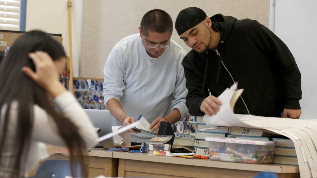 Teacher Joel Wing and Desmond Pueyrredon, 17, right, go over paperwork in his Oakland classroom.