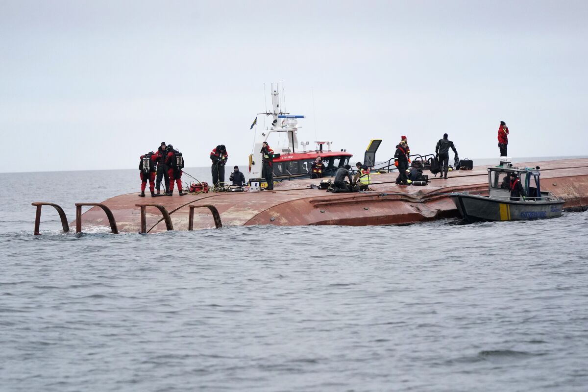 FILE - Divers work on the capsized Danish cargo ship Karin Høj after it collided with British cargo vessel Scot Carrier in the Baltic Sea, between Ystad and Bornholm, Sweden, Monday, Dec. 13, 2021. A 30-year-old British citizen who was the duty mate on a cargo ship that collided with another one off southern Sweden leaving two dead, was Tuesday, June 7, 2022 charged in Denmark with negligent manslaughter "in particularly aggravating circumstances" for having been intoxicated at the time of the collision. (Johan Nilsson/TT News Agency via AP, File)