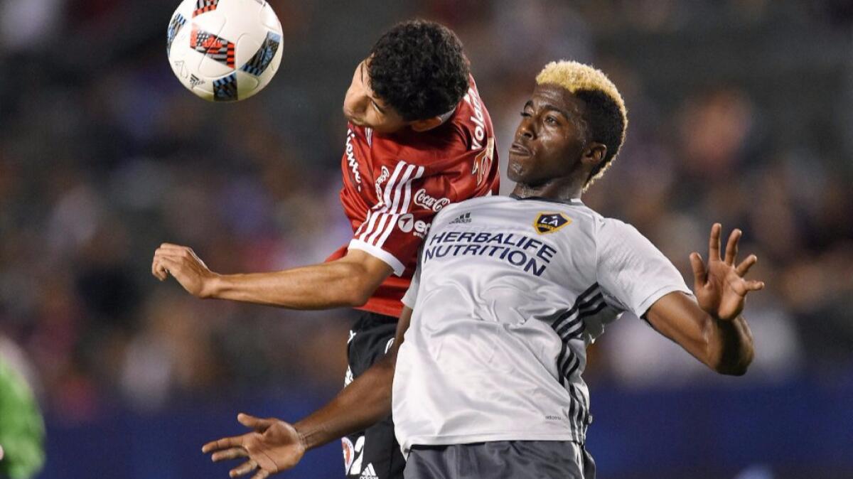 Galaxy forward Gyasi Zardes and Club Tijuana forward Miguel Rodriguez try to head the ball during the second half of a match on Feb. 9.