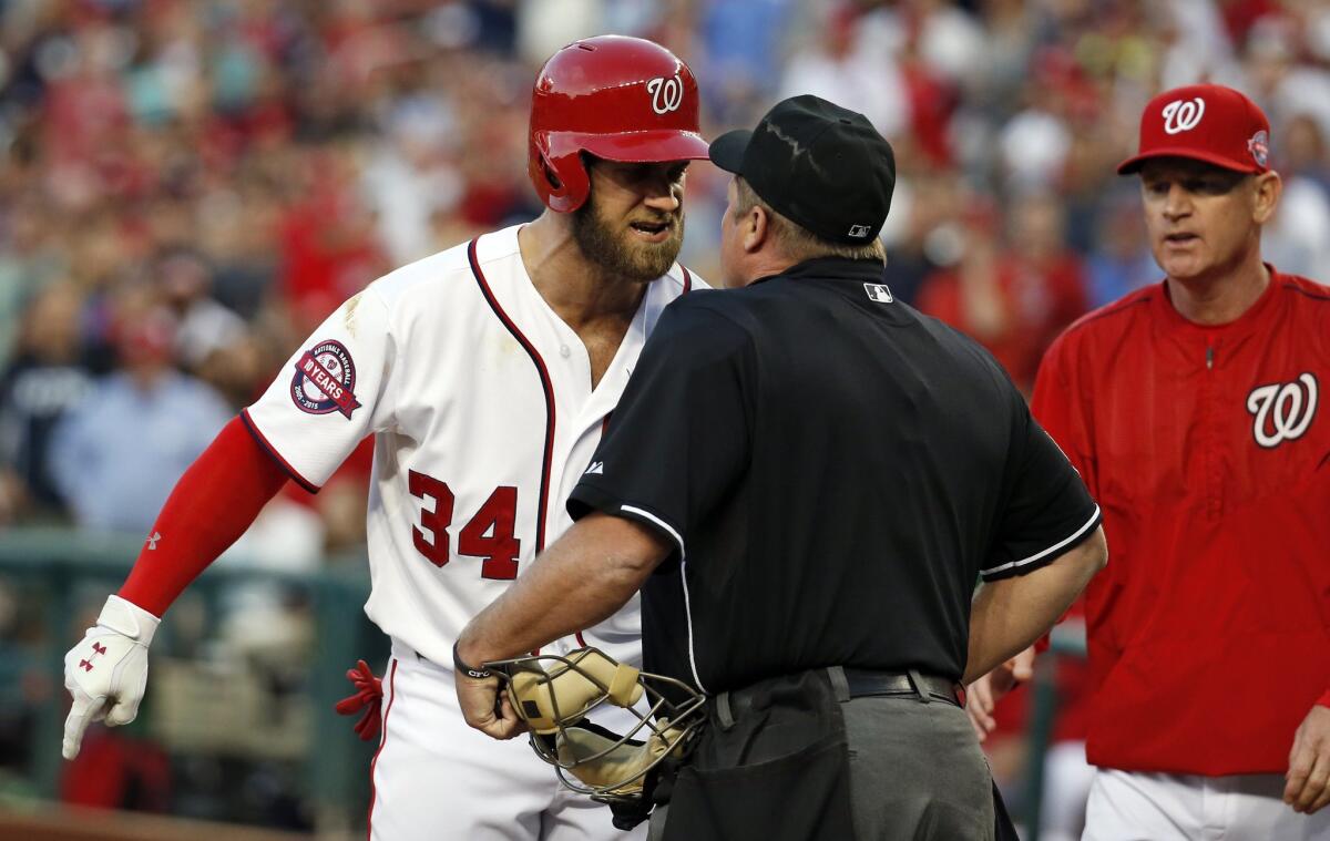 Washington's Bryce Harper argues with home plate umpire Marvin Hudson, as manager Matt Williams, right, walks up Wednesday night.